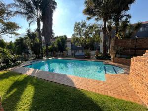 鲁德普特Royal Retreat的棕榈树庭院内的游泳池