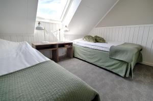 瓦尔贝里Apelviken Lägenhetshotell的阁楼卧室设有两张床和窗户。