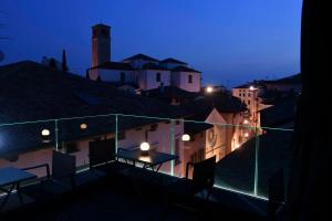 弗留利地区圣达尼埃莱Panorama Hotel Friuli - Boutique Hotel的阳台的桌子,晚上可欣赏到城市美景