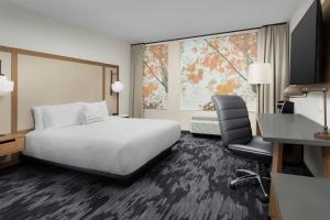 纳什维尔Fairfield Inn & Suites Nashville Near Vanderbilt的酒店客房配有一张床、一张桌子和一把椅子。