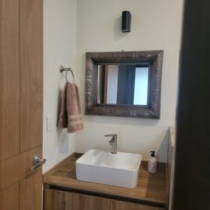 帕茨库卡罗Casita En Patzcuaro的浴室设有白色水槽和镜子