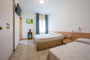 利多迪耶索罗基内弗拉酒店的酒店客房设有两张床和电视。