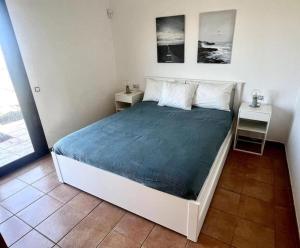 拉哈雷斯Dreamsville Fuerteventura a 5 minutos de Lajares的一间卧室配有一张带2个床头柜和2张桌子的床