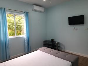 昂斯拉雷区Serenity Seaview Suite的一间卧室设有一张床和一个窗口