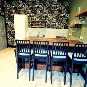 泰恩河畔纽卡斯尔The Queen Street Bunkhouse的厨房配有带四把椅子的桌子和水槽