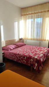 切尔维尼亚诺德尔夫留利Affittacamere Velocipede的一间卧室配有一张带红色和白色棉被的床