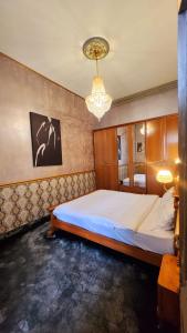 布加勒斯特NF Palace Old City Bucharest的一间卧室配有一张床和一个吊灯