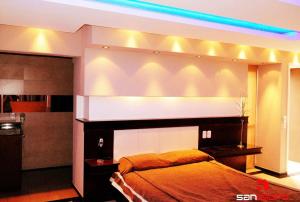 Las HerasSan Isidro Suite的一间卧室配有一张床和蓝色的灯光