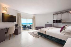 哥斯达雷Villa Escargot Luxury in Costa Rei Beach的一间卧室配有一张床、一张书桌和一台电视