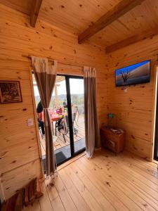 塞拉纳镇Cabaña Los Ceibos.的小木屋内的一个房间,设有大玻璃门