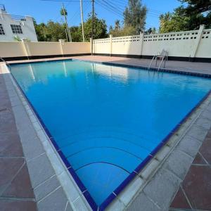 达累斯萨拉姆3BR Apt W/Pool&GYM Mikocheni的一个带喷泉的大型蓝色游泳池