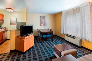 肯尼索亚特兰大肯尼索万豪广场酒店的客厅配有电视和桌子