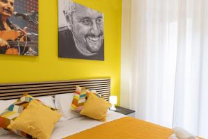 那不勒斯The HeArt Guest House的一间卧室拥有黄色的墙壁,床上配有黄色的枕头