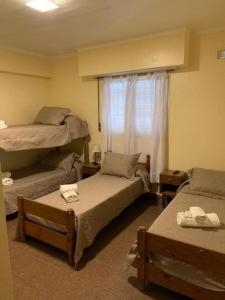 马德普拉塔Hotel gade的客房设有两张床和窗户。