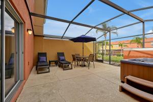 基西米Encantada Resort Vacation Townhomes by IDILIQ的庭院配有桌椅和遮阳伞。