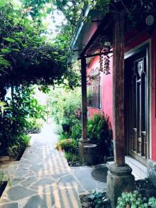 圣胡安拉拉古纳Casa I’x (Jaguar)的一条行人道,旁边是一座粉红色的房子,有一座建筑