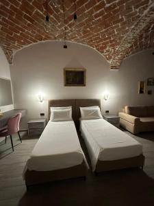 卡萨莱蒙费拉托Residenza Zotaj Small appartament的酒店客房,设有两张床和一张沙发