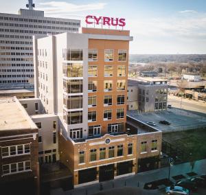 托皮卡Cyrus Hotel, Topeka, a Tribute Portfolio Hotel的一座高大的建筑,上面有标志