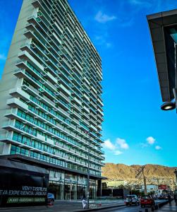 安托法加斯塔EcoApart Antofagasta的一座高大的建筑,前面有汽车停放