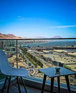 安托法加斯塔EcoApart Antofagasta的阳台享有城市美景,配有桌椅。