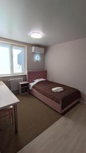 波尔塔瓦Гостьовий Будинок Апартаменти в тихому центральному районі Полтави Смарт-квартири的一间卧室配有一张床、一张桌子和一个窗户。