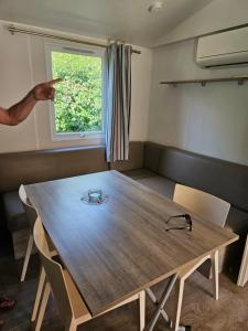 BoofzheimMobil-home climatisé (proximité EUROPA PARC)的一位指着一个房间里木桌的人