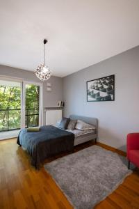 华沙ClickTheFlat Artistic Estate Apartment的一间卧室配有一张床和一张红色椅子