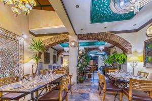 西尔韦斯Casa Riad Yasmin的一个带桌椅的用餐室和一个拱门