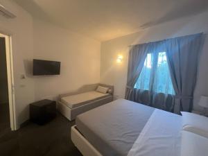 布多尼Acquamarina Luxury Rooms的酒店客房设有两张床和窗户。