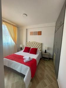 圣罗莎德卡瓦尔Moderno apto familiar piso 2的一间卧室配有一张带红色枕头的大床