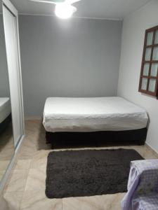 卡波布里奥housecabofrio的一间白色卧室,配有一张床和黑色地毯