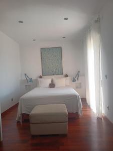 阿瓜杜尔塞Habitación con vistas的白色卧室配有白色的床和椅子