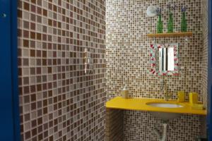 萨尔瓦多Tamboleiro's Hotel Residence的浴室设有黄色水槽和镜子