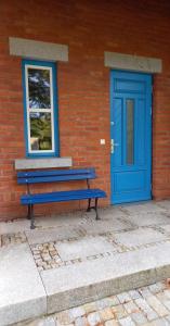 克拉科夫U Janciów的蓝色长凳,靠近一座带蓝色门的建筑