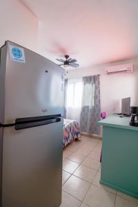 马萨特兰Habitación Privada en Zona Dorada的一间带床的客房内配有冰箱的厨房
