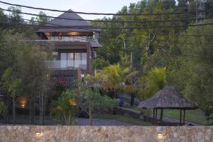 龙目岛库塔Villa Mandalika Lombok的一座树木繁茂的院子中的房子