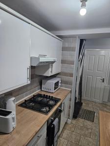 利物浦Hawkins House的厨房配有白色橱柜和炉灶烤箱。