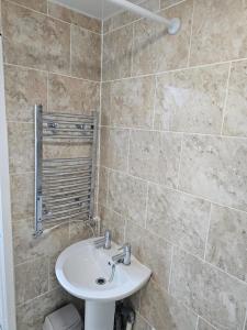 利物浦Hawkins House的一间带水槽和瓷砖墙的浴室