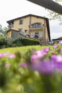 CaminoCountry House La Mela Ruscalla的前面有紫色花的房屋