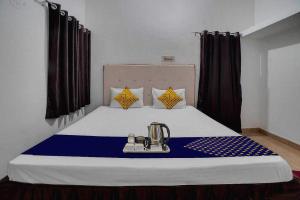 比莱OYO Hotel Rudraksh Residency的一间设有一张蓝色和白色床罩的床的房间