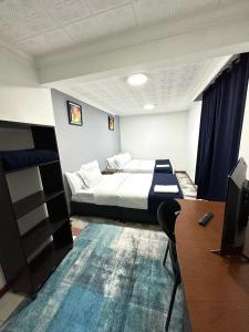 波哥大Way Maker sede 2的酒店客房设有一张床、一张书桌和一台电视机。