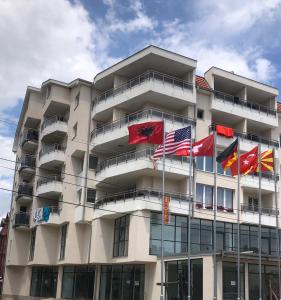 斯特鲁加Hotel Palace Struga的前面悬挂着旗帜的建筑