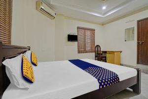 柴瑞海滩SPOT ON 81226 Cherai Rest Home的一间卧室配有一张黄色和蓝色的床铺