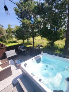 康福斯Keer Side Lodge, Luxury lodge with private hot tub at Pine Lake Resort的庭院顶部设有按摩浴缸。