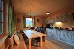 达米尔斯Feriendorf Walserland的一间带木桌的客厅和一间厨房