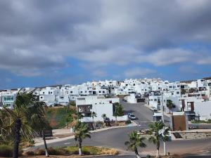 Harry ManzoNew panoramic Ocean view relaxing home Rosarito BC的享有白色建筑和棕榈树的城市美景