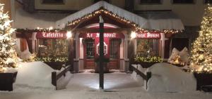 布勒伊-切尔维尼亚萨莫瓦宾馆的雪中带圣诞灯的商店前