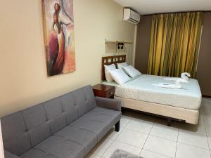 帕拉马里博101 Suites的一间带沙发和床的卧室以及一幅画