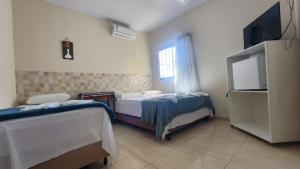 伊比科阿拉Hotel Raio do Sol的客房设有两张床和一台平面电视。