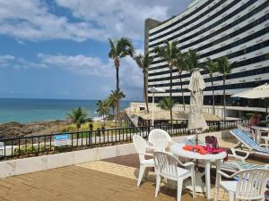 萨尔瓦多@ondinaapartreservas Pé na Areia 441的一个带桌椅的庭院和大海
